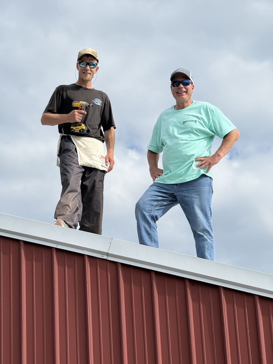 Two of the Andy's Roofing crew on a barn roof