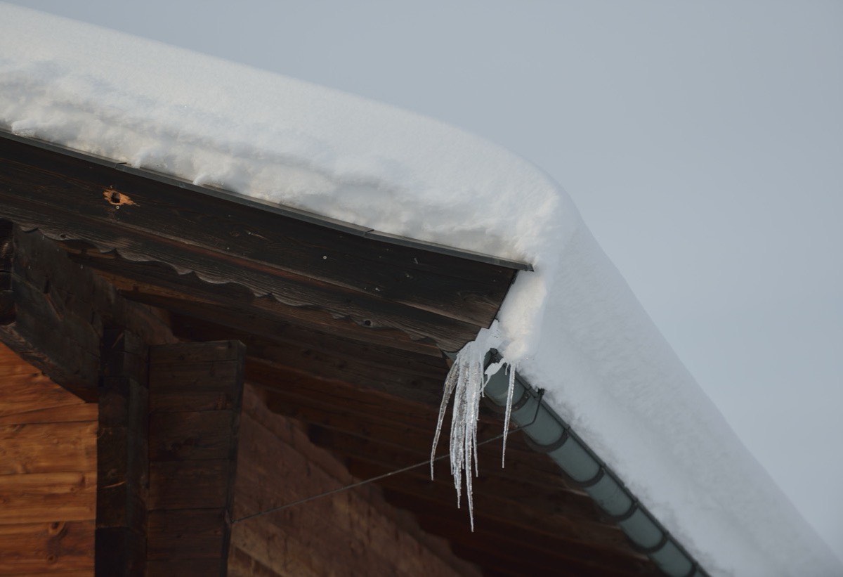 Deep snow sitting on a shingled roof